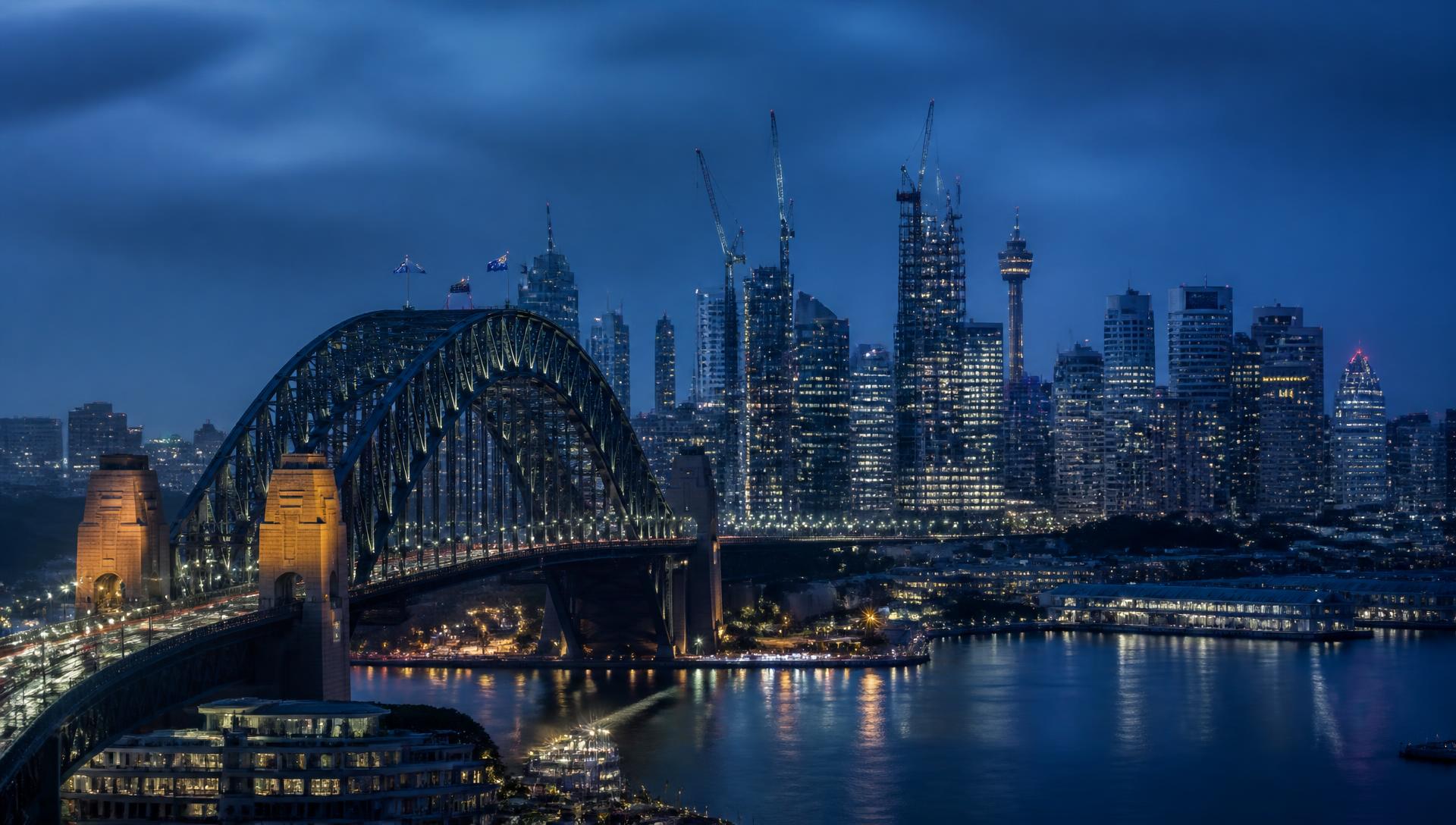Sydney harbour skyline with construction cranes at dusk